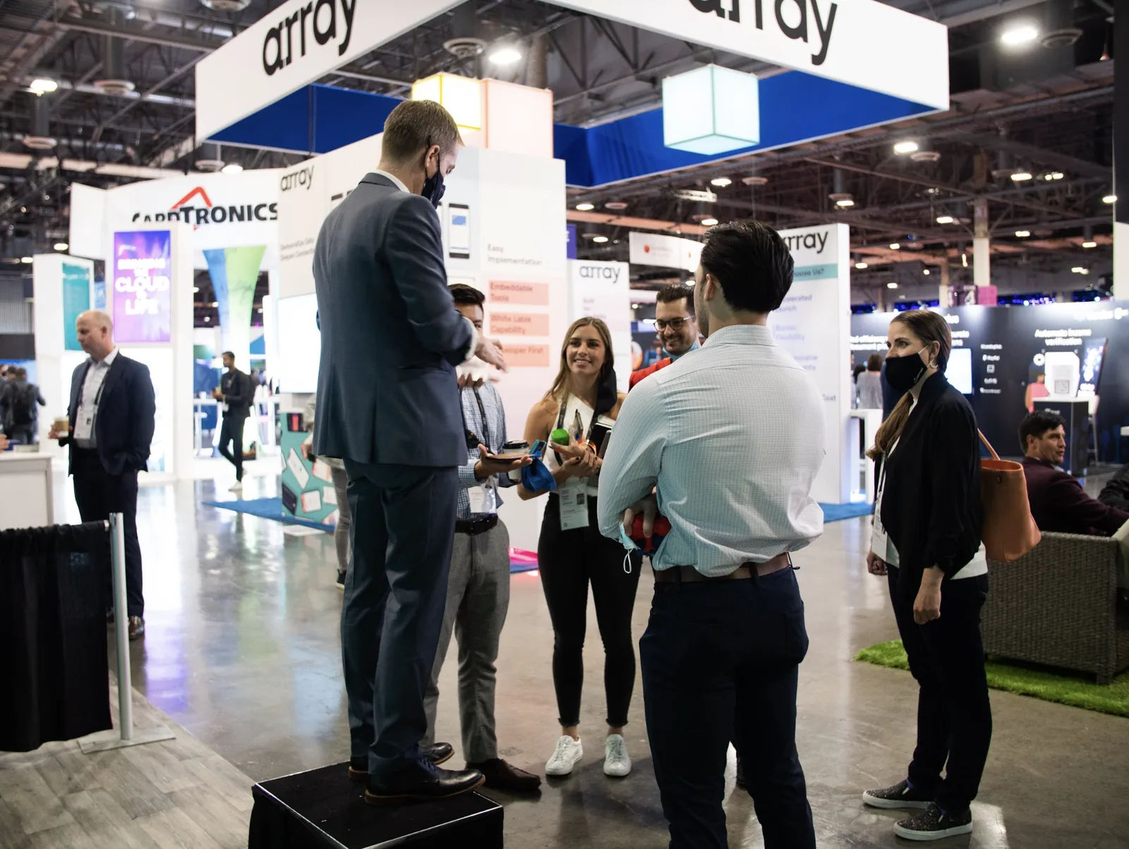Crowd gathered at the Outseer conference booth during a live demonstration.